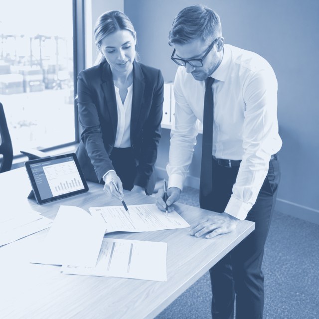 Two specialists reviewing and signing customs paperwork